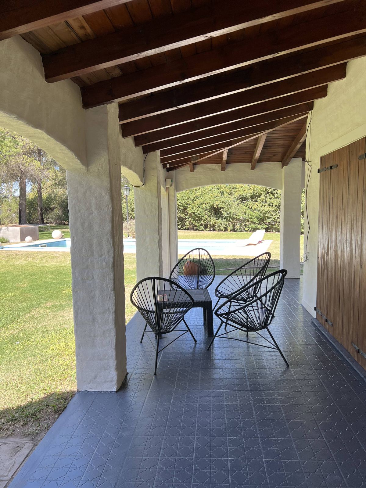 Galería con sillones y vista a la pileta